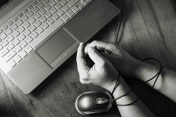 a photo of human hands being chained by computer cables