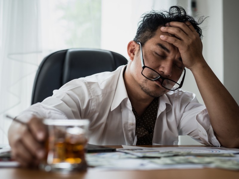 man stressed at work drinking