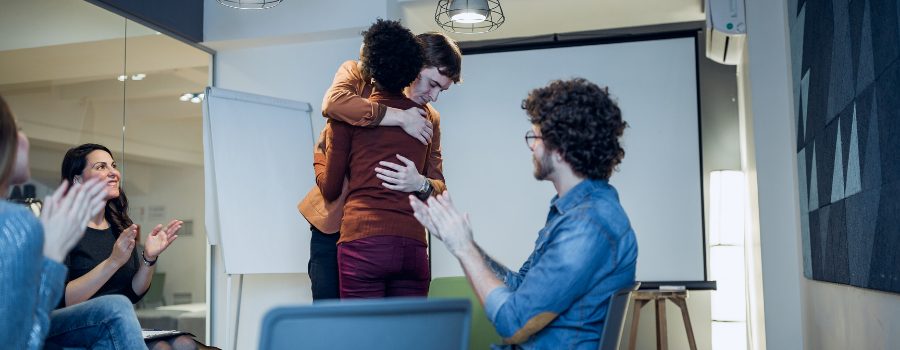 Two people embracing in group therapy