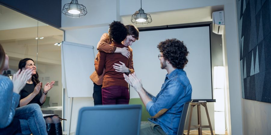 Two people embracing in group therapy