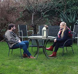 Photo of two people sitting on a table in the garden